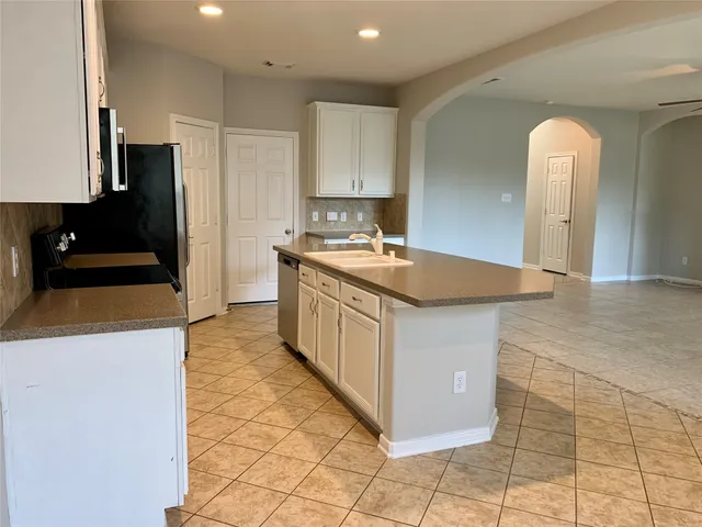 a kitchen with a sink stove and refrigerator