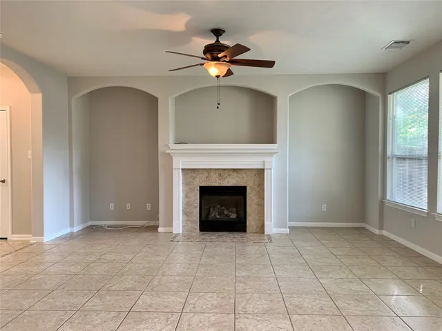 a living room with a fireplace furniture a rug and a large window