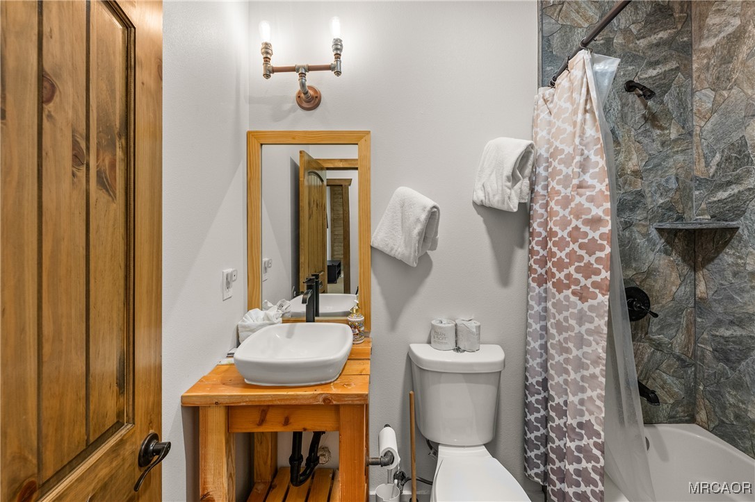855 Conklin Road Big Bear Lake, CA 92315 - Photo 21 of 44 a bathroom with a sink a toilet and shower curtain