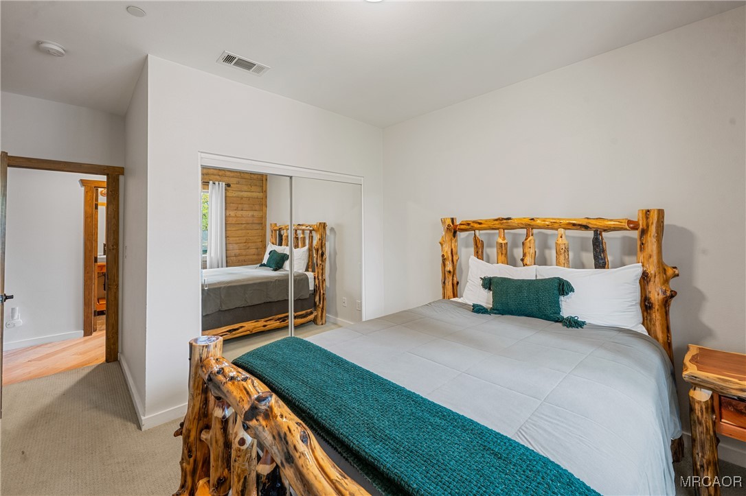 855 Conklin Road Big Bear Lake, CA 92315 - Photo 24 of 44 a bedroom with a bed and wooden floor