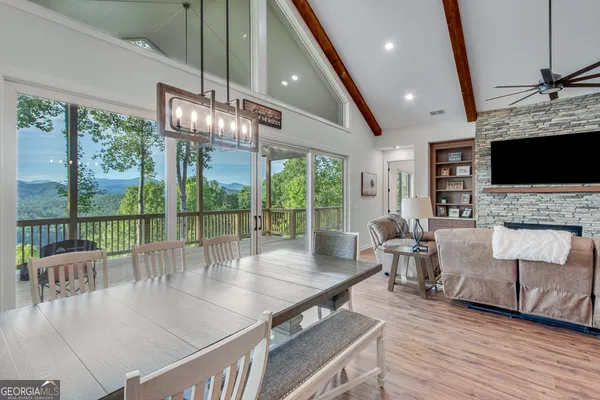 a living room with furniture large windows and flat screen tv