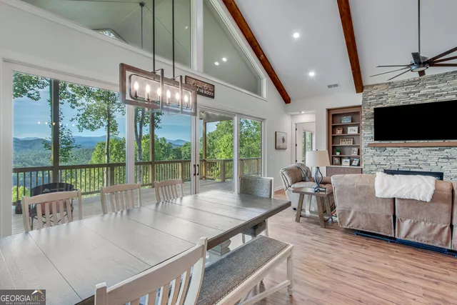 a living room with furniture large windows and flat screen tv