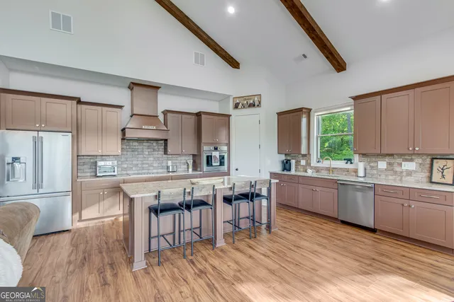 a large kitchen with kitchen island a wooden floor and white cabinets