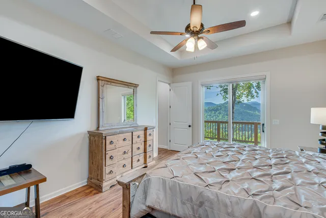 a bed room with a bed a television and a large window