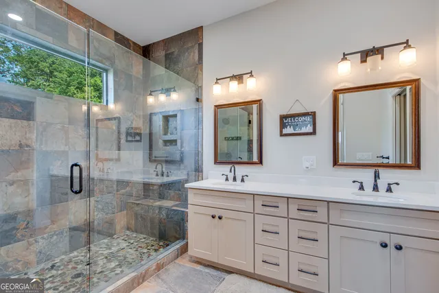 a bathroom with a double vanity sink mirror and shower