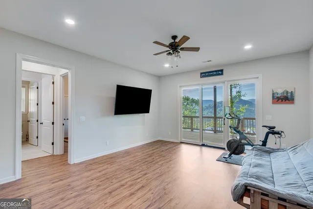 a living room with furniture a flat screen tv and a large window