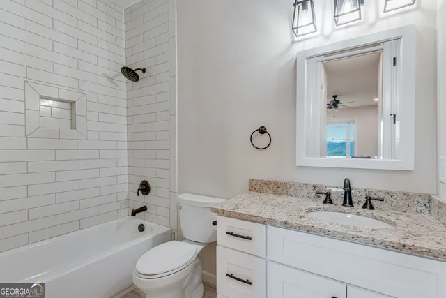 a bathroom with a granite countertop toilet a sink and a bathtub