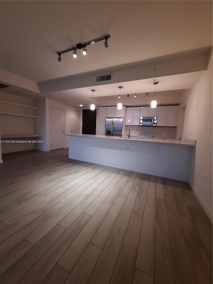 999 Southwest 1st Avenue, Unit 2705 Miami, FL 33130 - Photo 20 of 24 an empty room with wooden floor