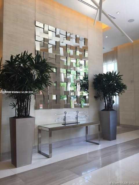 999 Southwest 1st Avenue, Unit 2705 Miami, FL 33130 - Photo 8 of 24 a vase of flowers sitting on a table with window