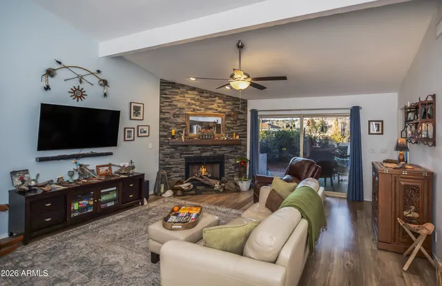 a living room with furniture a flat screen tv and a fireplace
