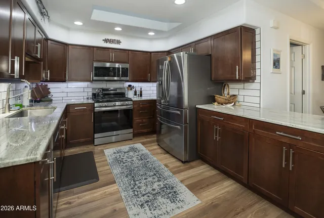 a kitchen with stainless steel appliances granite countertop a stove refrigerator and microwave