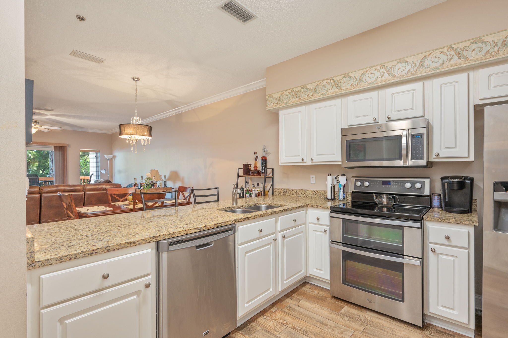 5 Laguna Street, Unit 104 Fort Walton Beach, FL 32548 - Photo 2 of 40 a kitchen with granite countertop a sink stainless steel appliances and white cabinets