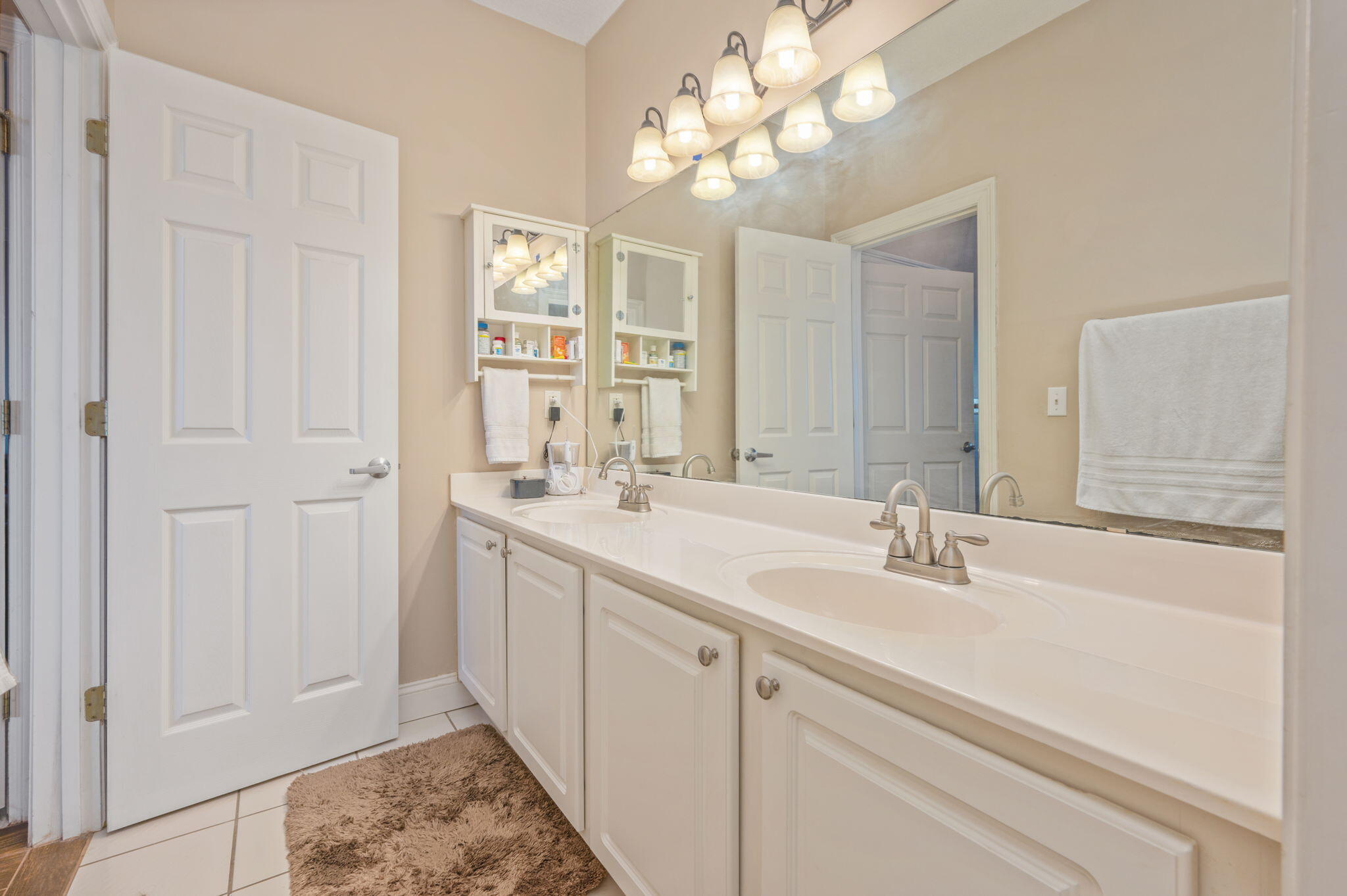 5 Laguna Street, Unit 104 Fort Walton Beach, FL 32548 - Photo 23 of 40 a bathroom with a double vanity sink and a mirror