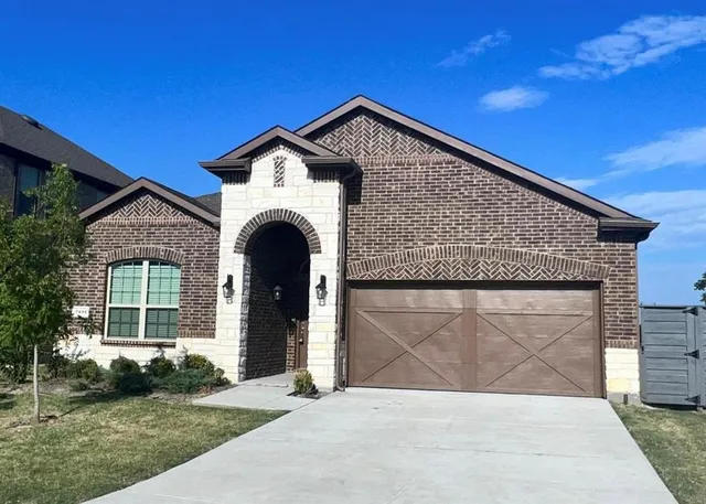 a front view of a house with a garden and plants
