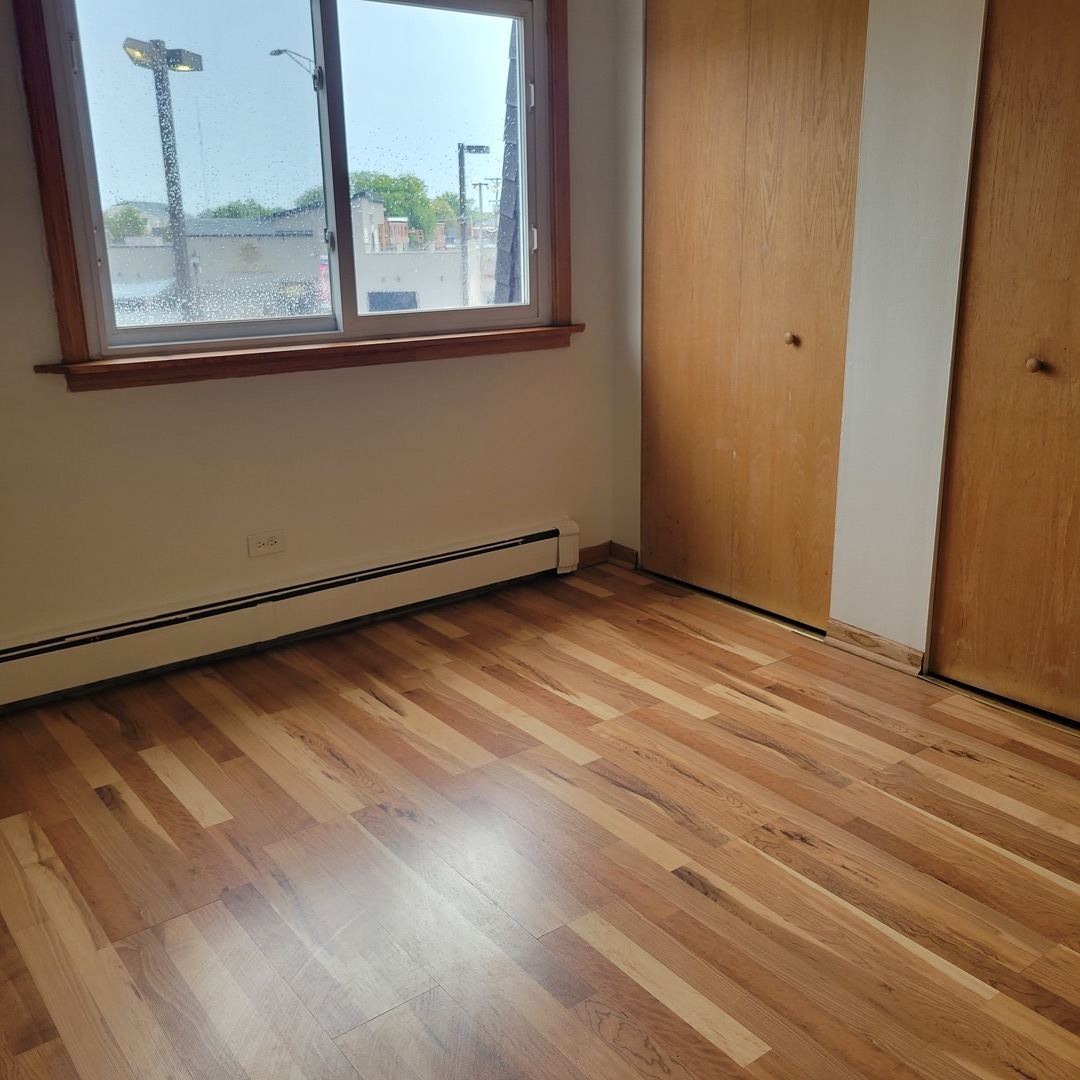 10330 Ridgeland Avenue, Unit 308 Chicago Ridge, IL 60415 - Photo 6 of 9 a view of an empty room with wooden floor and a window