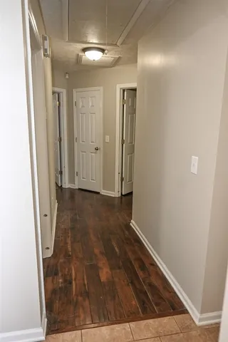 an empty room with a chandelier fan and closet