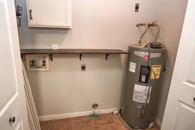 a kitchen with granite countertop a refrigerator and a stove top oven