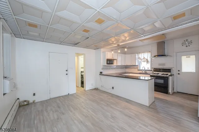 a large kitchen with kitchen island a stove a sink dishwasher and a refrigerator with wooden floor