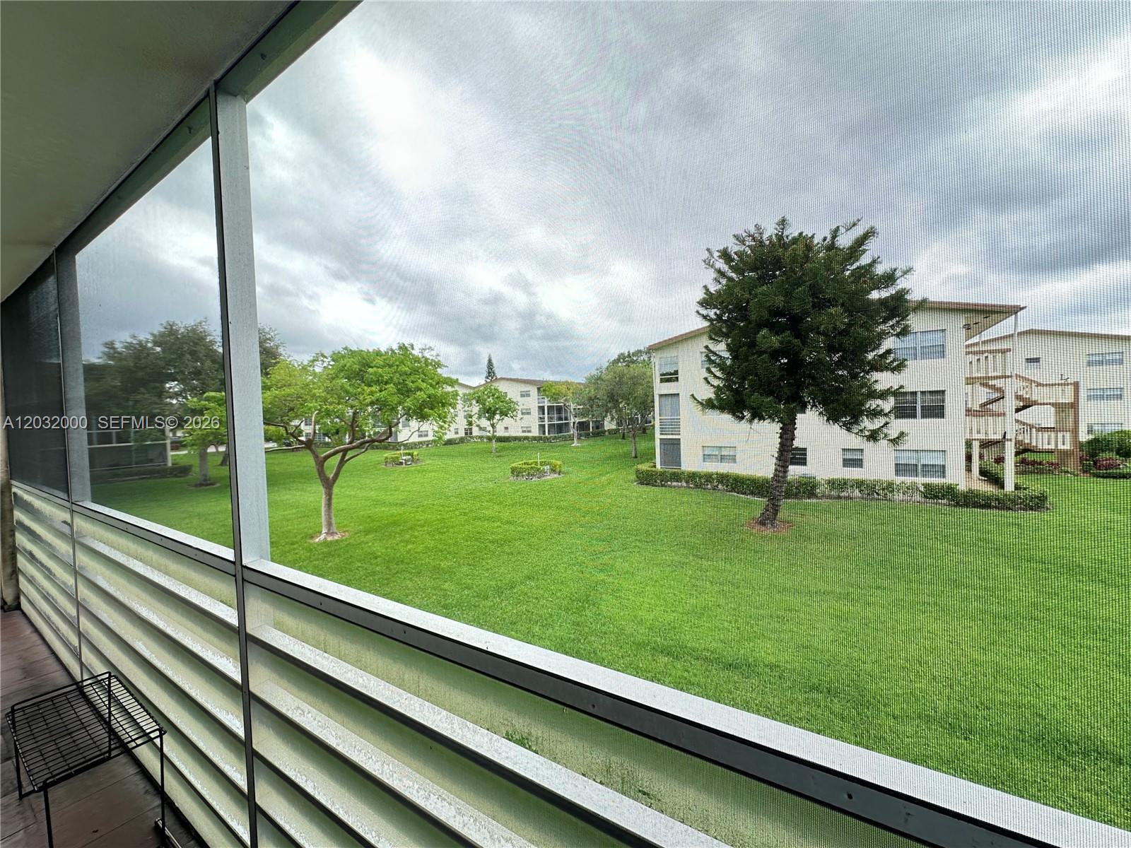 445 Mansfield K, Unit 445 Boca Raton, FL 33434 - Photo 10 of 12 a view of swimming pool with a garden and trees