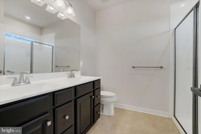 a bathroom with a double vanity sink toilet and a mirror