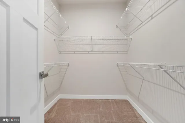 a view of walk in closet with empty racks