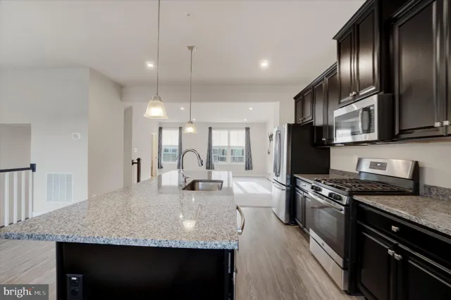 a kitchen with granite countertop stainless steel appliances and wooden cabinets