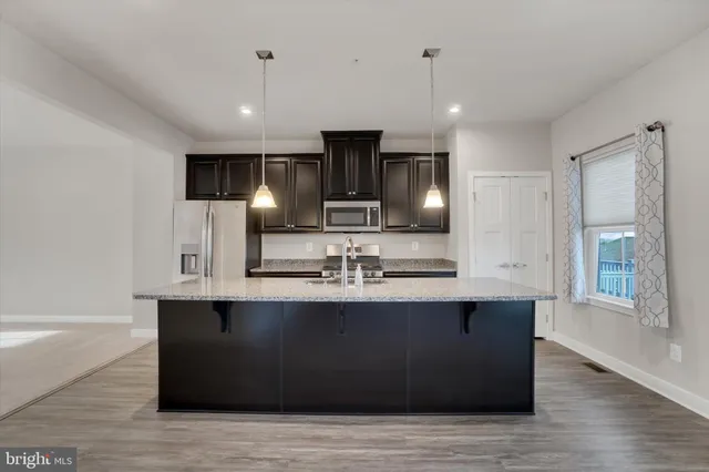 a large white kitchen with kitchen island a sink and a stove top oven