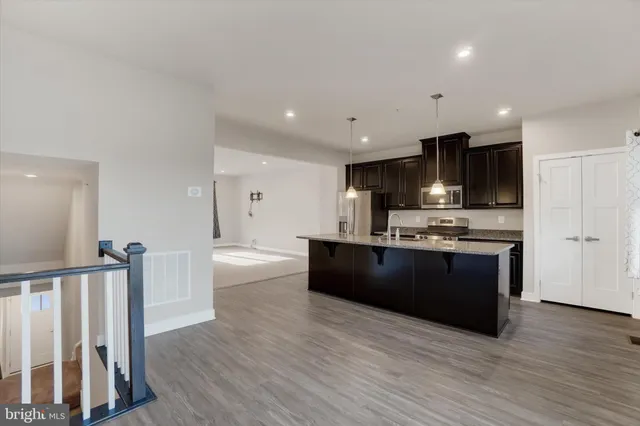 a kitchen with stainless steel appliances kitchen island granite countertop a stove a refrigerator and cabinets