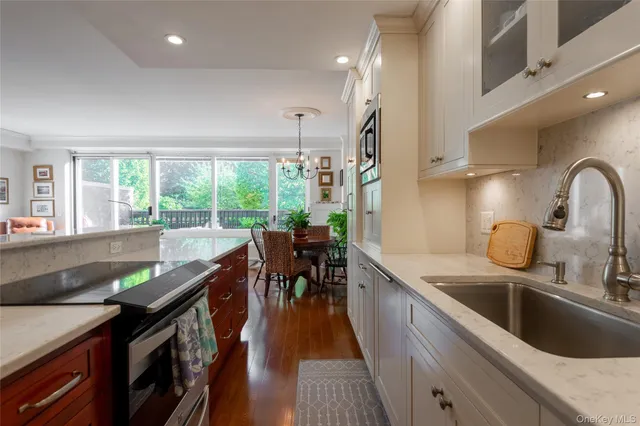 a kitchen with kitchen island granite countertop a sink a counter top space and stainless steel appliances