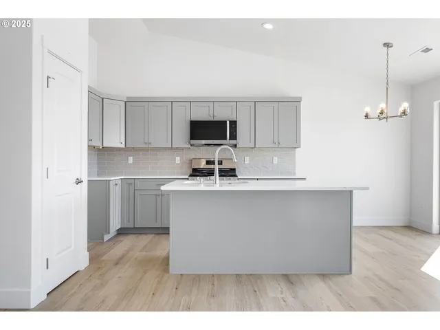 a kitchen with kitchen island white cabinets and stainless steel appliances