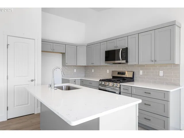 a kitchen with stainless steel appliances granite countertop a sink stove and refrigerator
