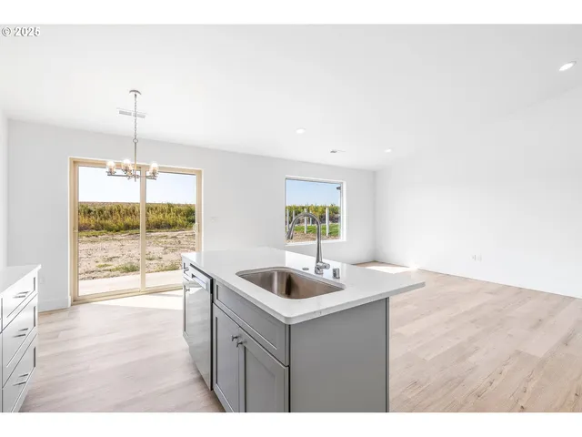 a kitchen with a sink and wooden floor