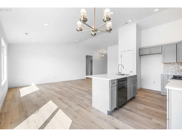 a kitchen with granite countertop a stove a sink and a refrigerator