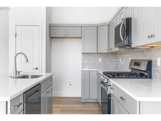 a kitchen with stainless steel appliances granite countertop a sink stove and cabinets