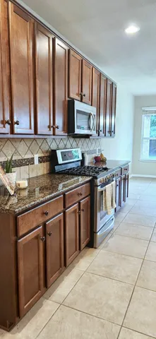 a kitchen with stainless steel appliances granite countertop a stove sink and cabinets