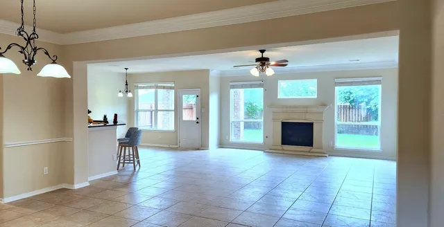 a view of an empty room with a fireplace and a chandelier