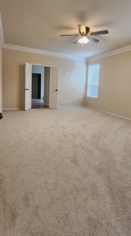 a view of a room with a ceiling fan and a window
