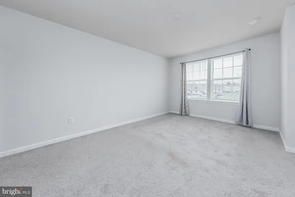 a spacious bedroom with a bed and a window