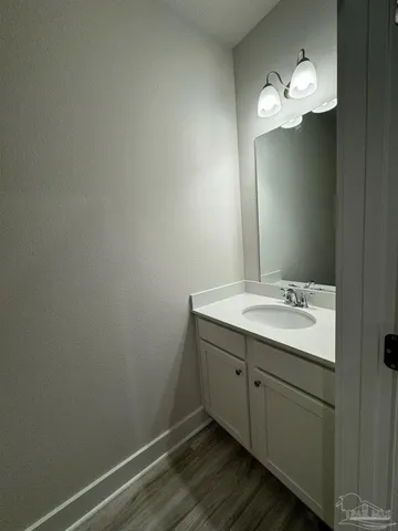 a toilet sitting in a bathroom next to a wooden wall