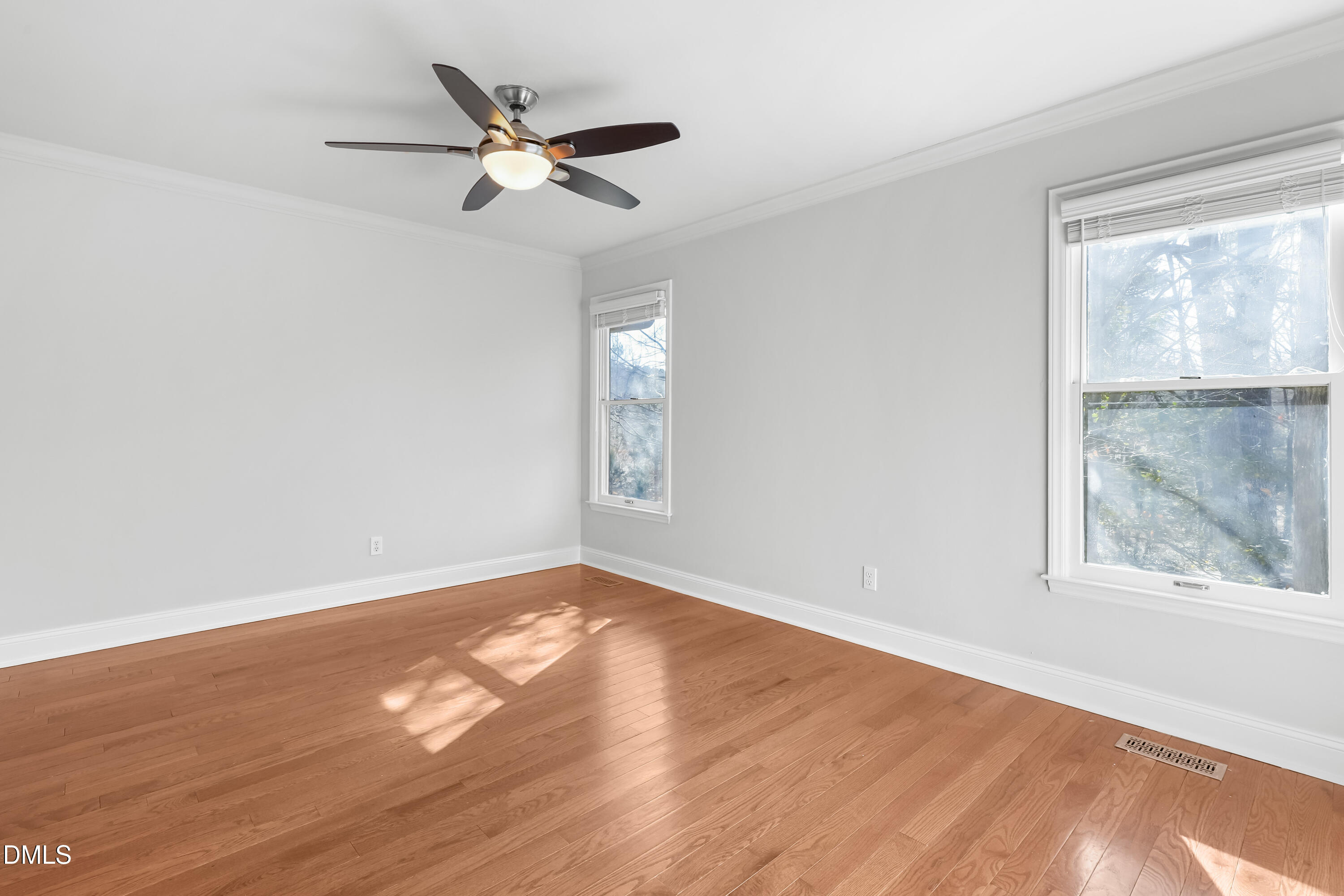 3504 Fairhill Drive Raleigh, NC 27612 - Photo 23 of 45 an empty room with wooden floor fan and windows