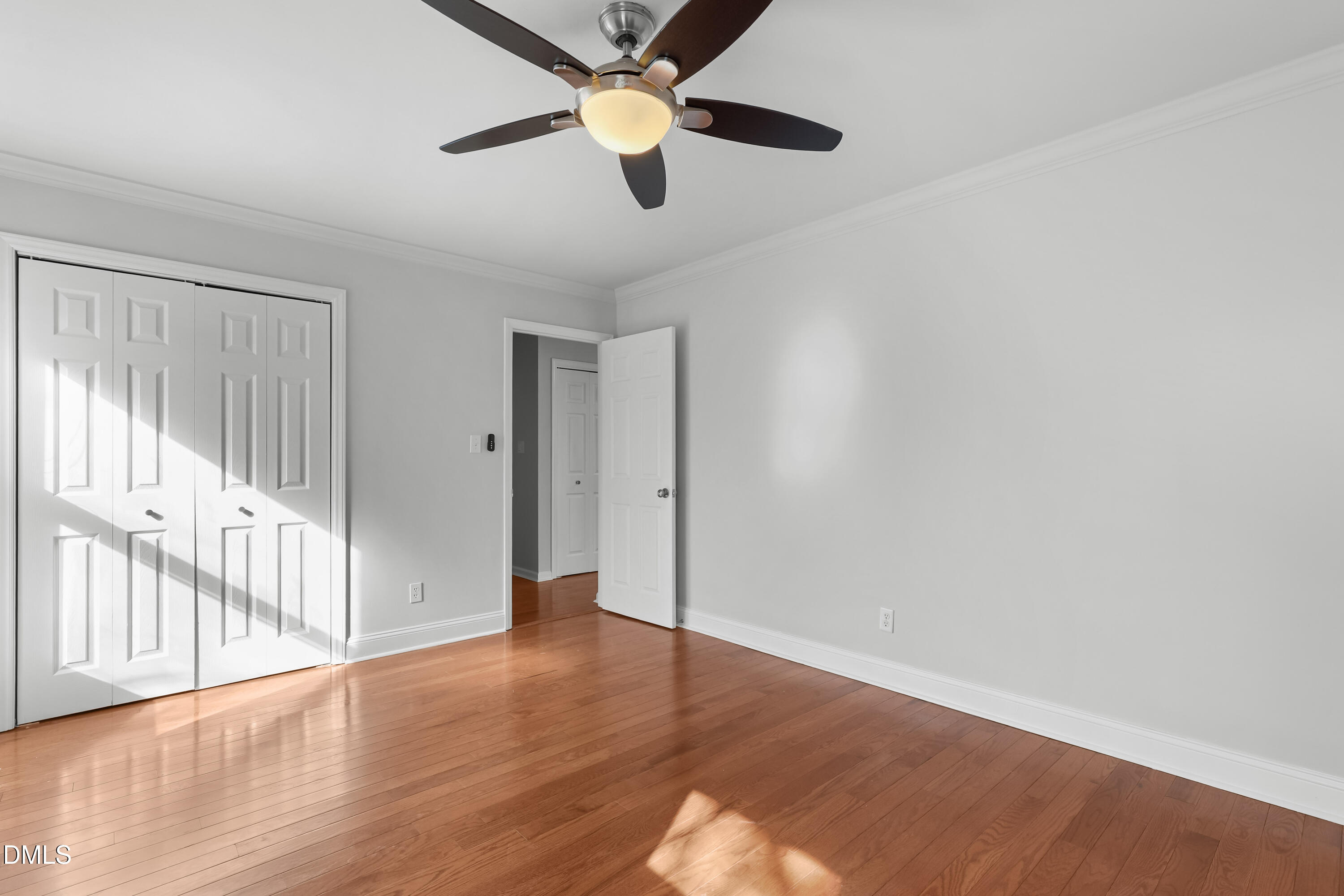 3504 Fairhill Drive Raleigh, NC 27612 - Photo 24 of 45 an empty room with wooden floor fan and windows