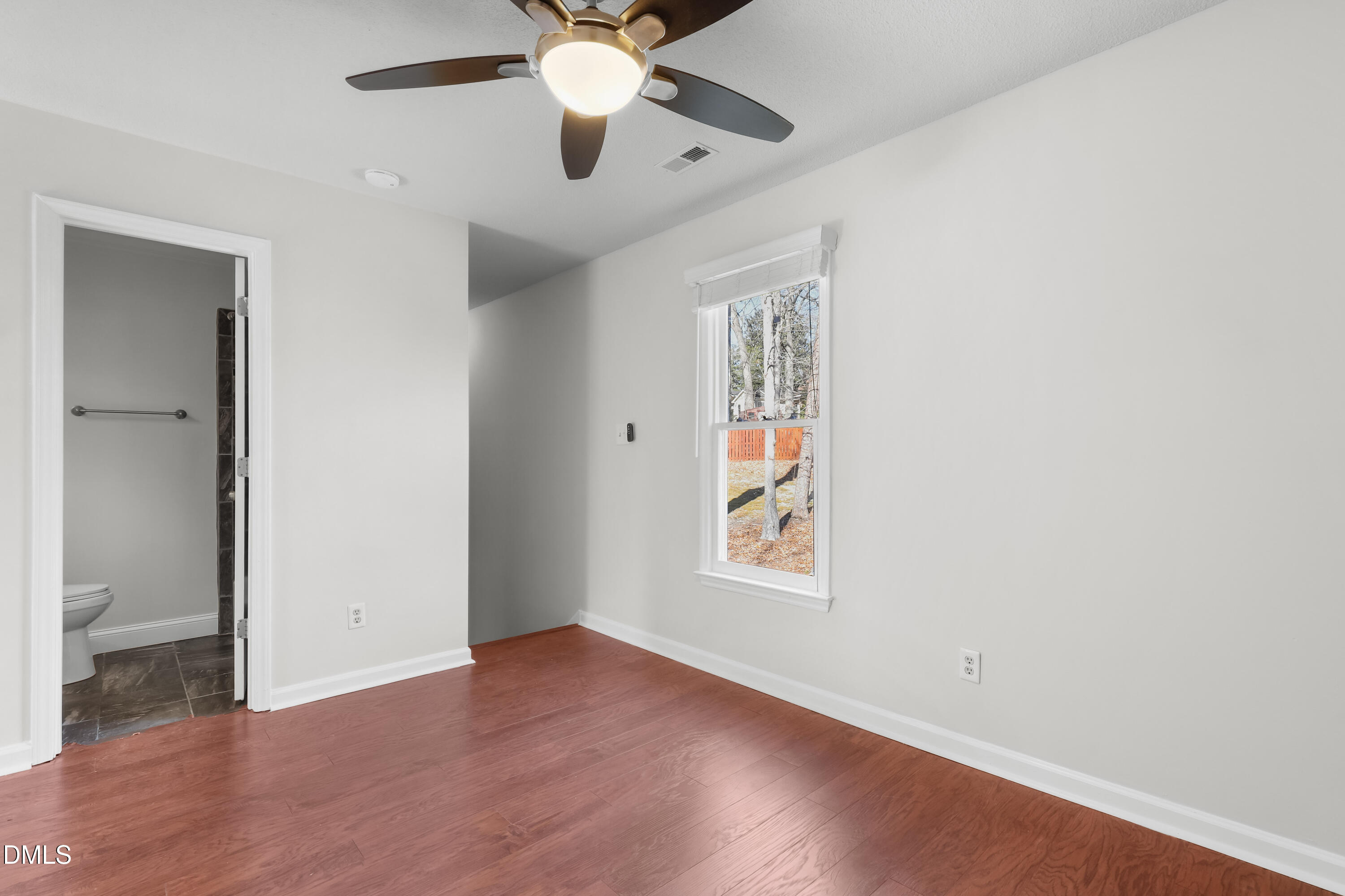 3504 Fairhill Drive Raleigh, NC 27612 - Photo 31 of 45 an empty room with wooden floor chandelier fan and windows