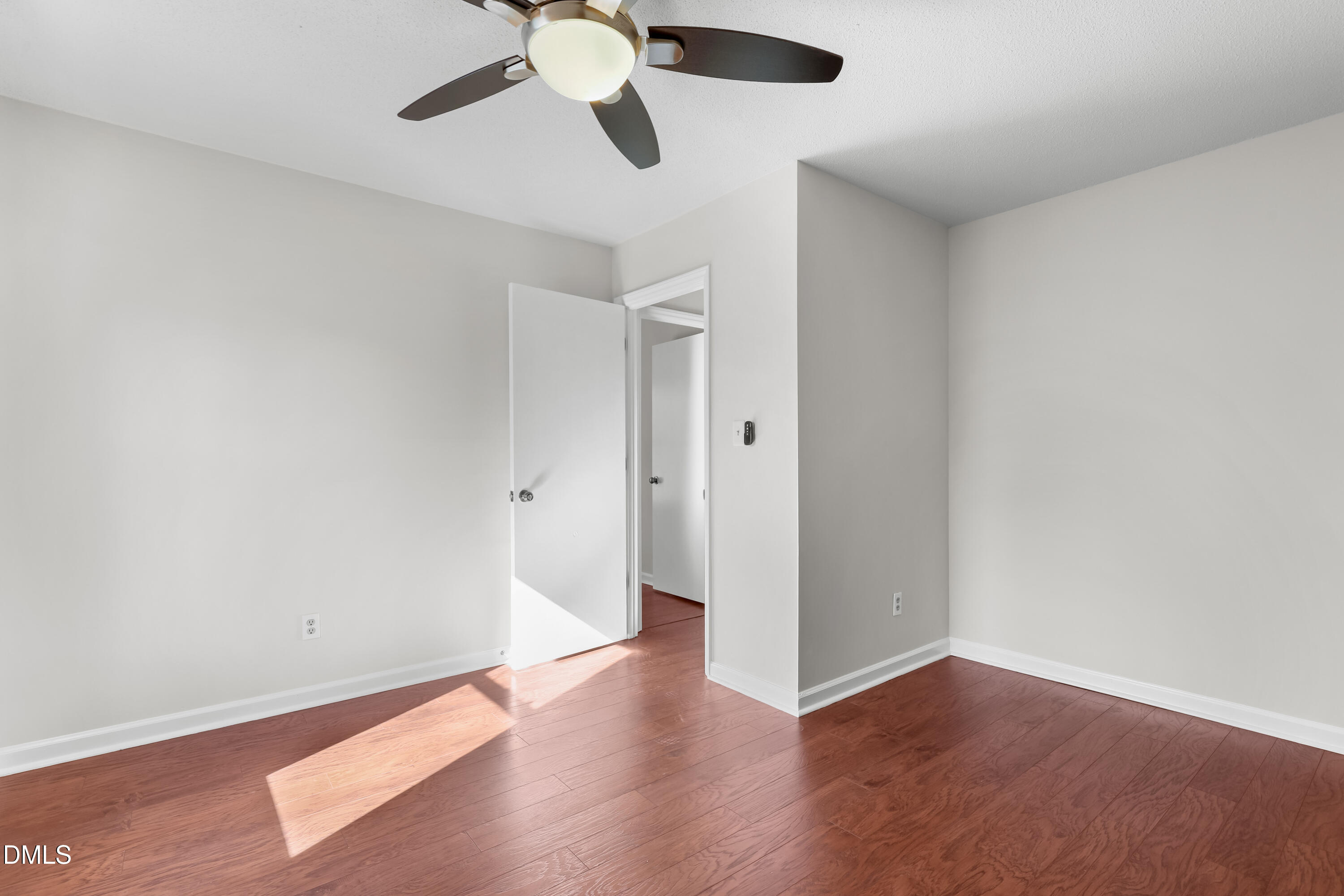3504 Fairhill Drive Raleigh, NC 27612 - Photo 37 of 45 an empty room with wooden floor ceiling fan and window