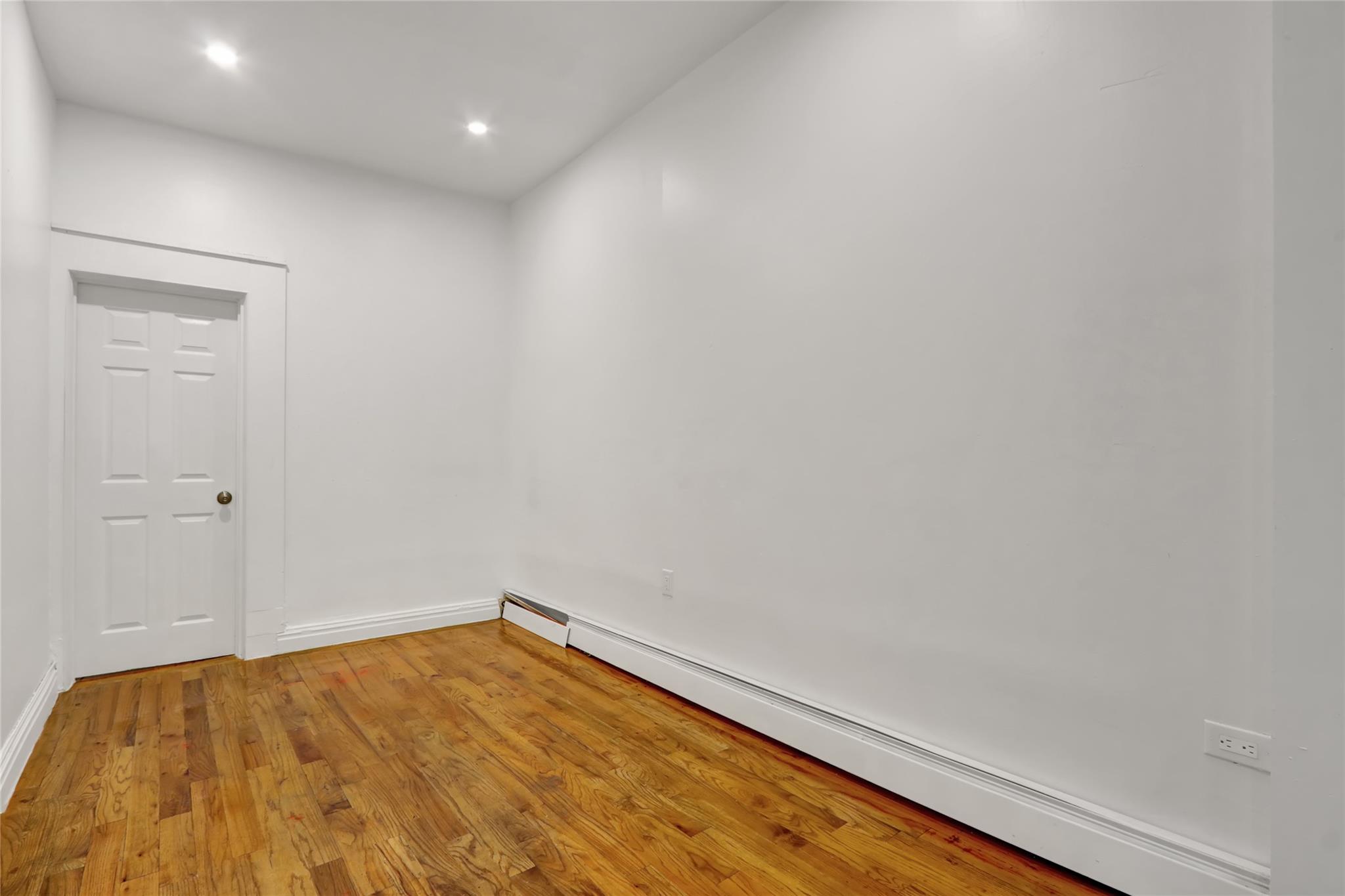 119-15 101st Avenue Queens, NY 11419 - Photo 5 of 20 Unfurnished room with baseboard heating, light wood-style flooring, and recessed lighting