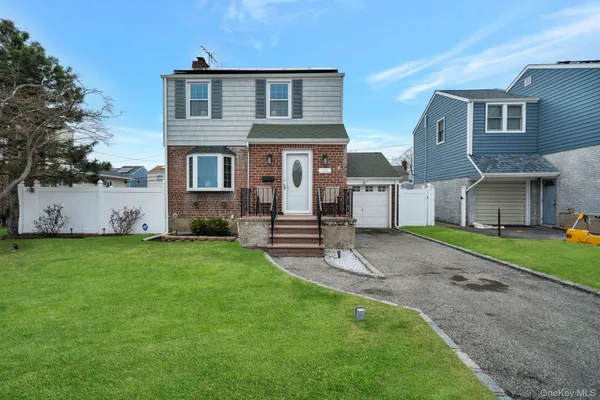 a front view of house with yard and garage