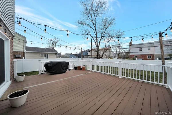 a view of a house with wooden deck and a barbeque grill with granite floor