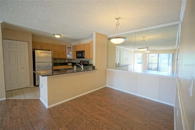 a kitchen with stainless steel appliances granite countertop a refrigerator a stove a sink and a microwave