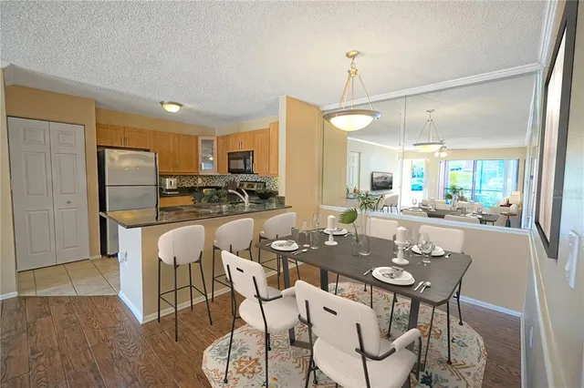a kitchen with a dining table chairs refrigerator and cabinets