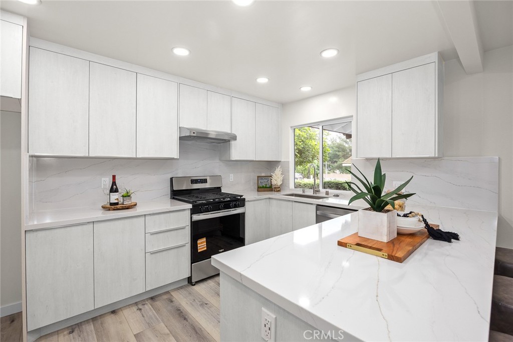 21030 East Riego Drive Diamond Bar, CA 91765 - Photo 15 of 42 a kitchen with stainless steel appliances kitchen island granite countertop a sink a stove and white cabinets