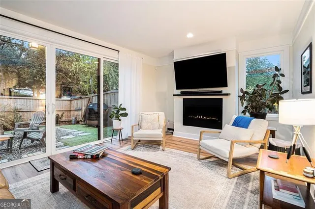 a living room with furniture flat screen tv and a large window